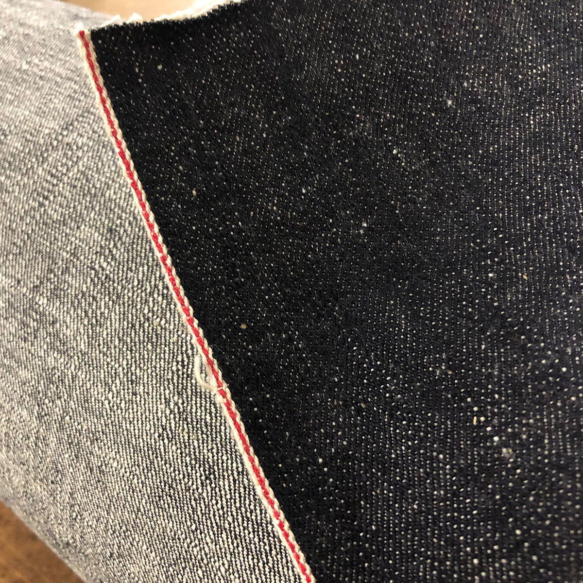 Close-up of Japanese indigo denim fabric showing the texture and frayed edges.