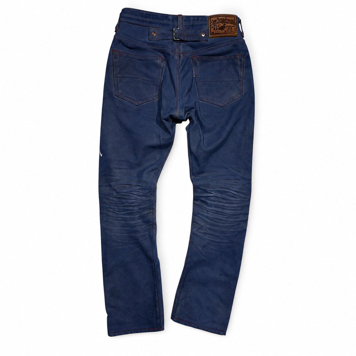 A pair of dark blue denim jeans shown from the back, featuring a brown leather patch on the waistband and classic rear pocket stitching, laid flat against a white background.