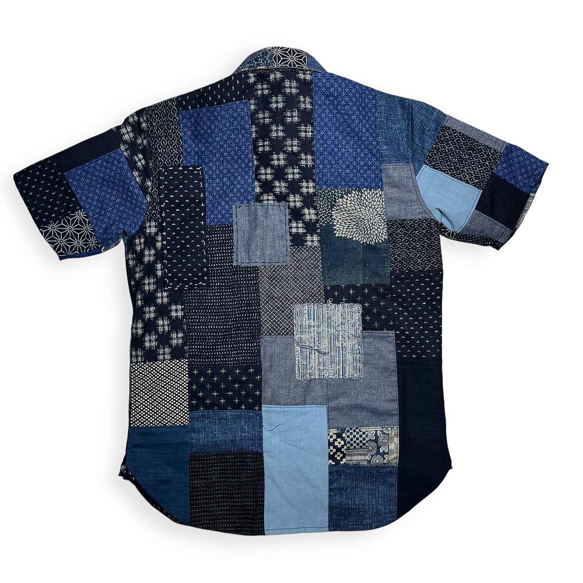 Patchwork shirt with various blue patterns on a white background